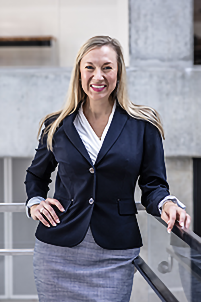 Ashley Jennings, managing director of Innovation Center, smiling while sitting outside among some bushes